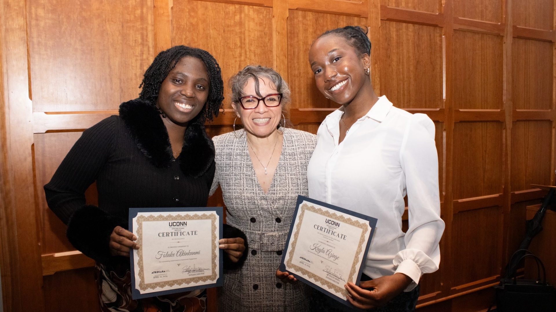 Photo of Foluke Akinkunmi and Kayla Azinge, recipients of the Community Engagement Award, standing alongside Evelyn Simien