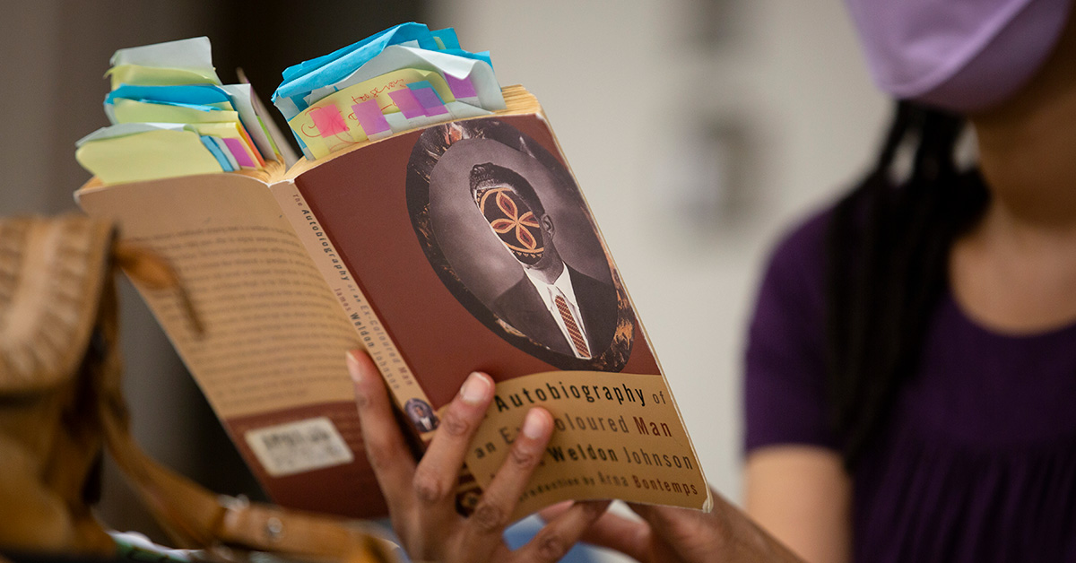 A person holds open a copy of the book "Autobiography of an Ex-Colored Man."