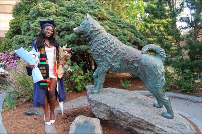 Tae'Niajha Pullen posing next to Husky Dog Statue